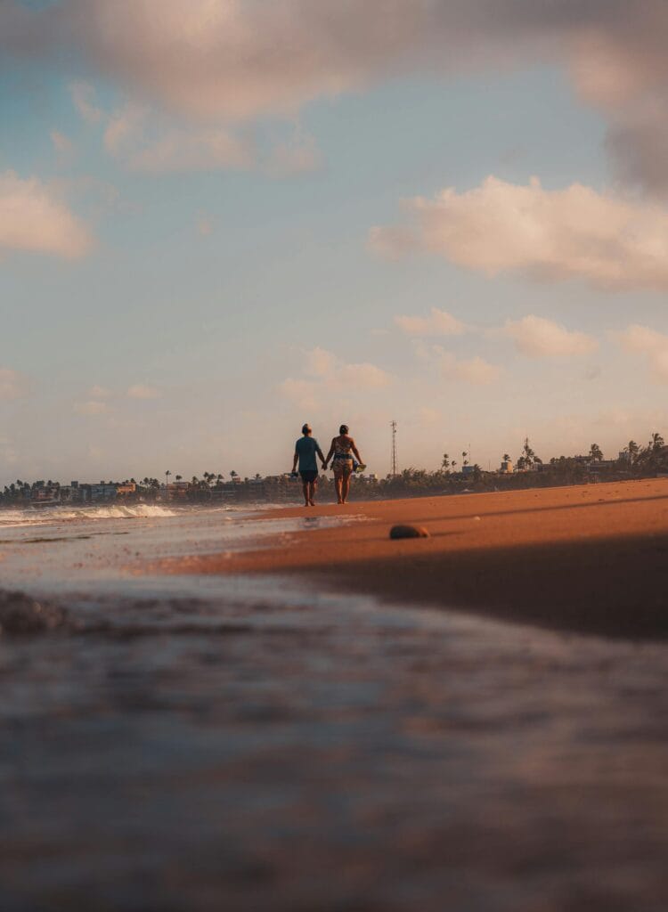 Lua de mel em Porto de Galinhas — casal caminhando ao pôr do sol