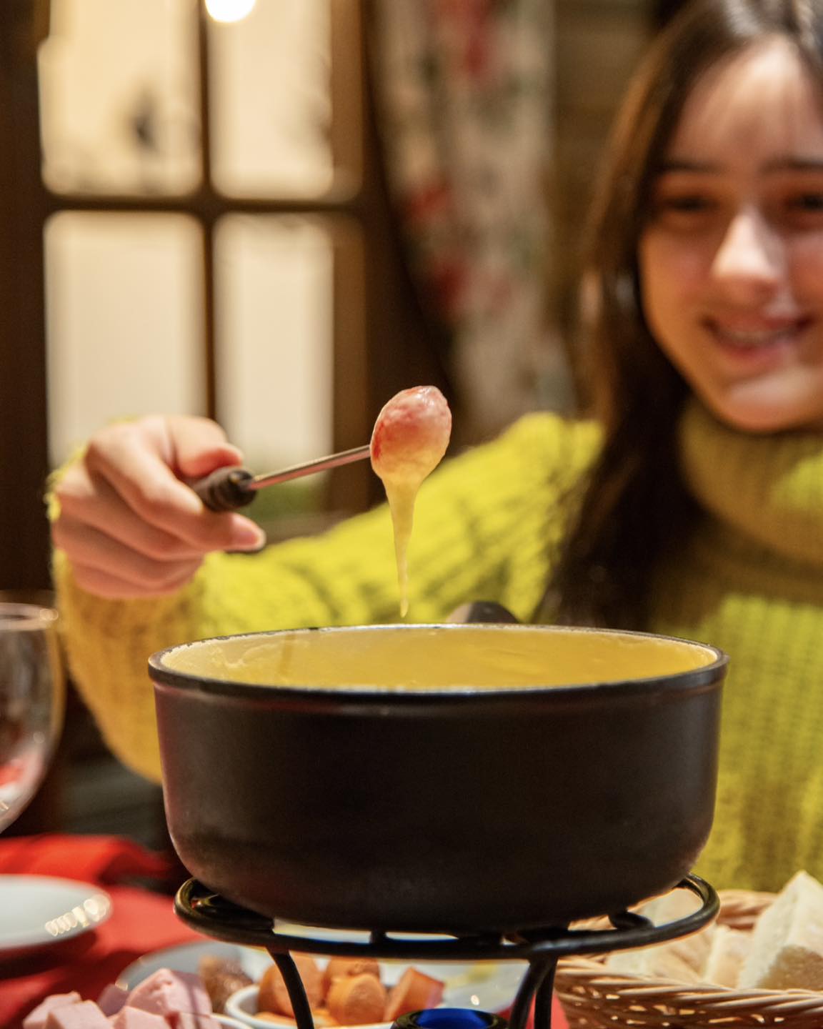 Fondue de queijo no restaurante La Marmite em Bariloche, com fio de queijo derretido no garfo