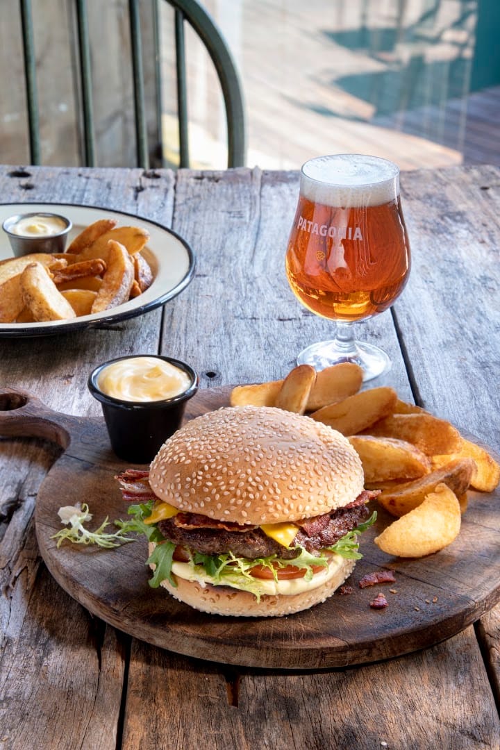 Hambúrguer com batatas e taça de cerveja artesanal na Patagonia Brewery em Bariloche