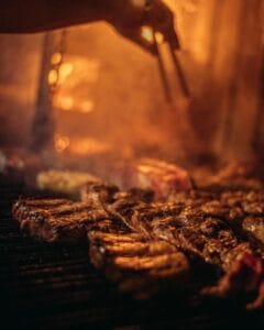 Carnes assando sobre brasas na parrilla do Alto El Fuego, restaurante em Bariloche
